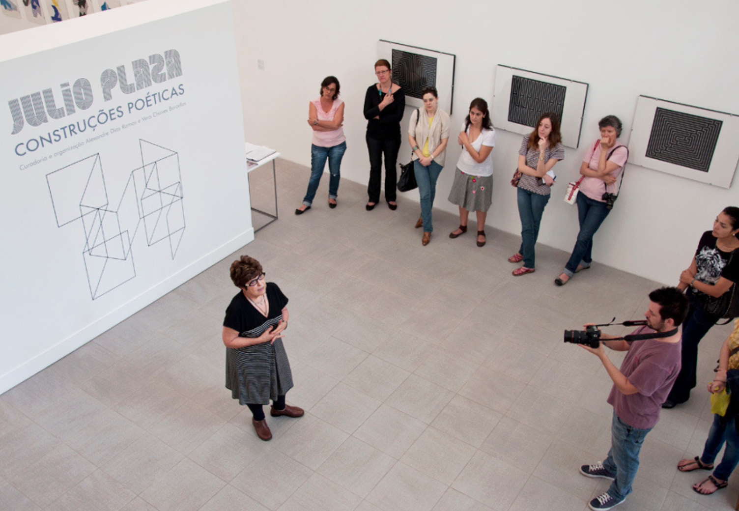 2012 | Exposição "Julio Plaza, construções poéticas", com curadoria de Alexandre Dias Ramos e Vera Chaves Barcellos, em cartaz de 15 de setembro a 21 de dezembro de 2012, na Sala dos Pomares, em Viamão. Na imagem, registro da visita mediada com a artista Regina Silveira.